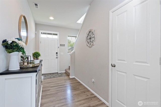 foyer with visible vents, light wood-type flooring, stairs, baseboards, and recessed lighting