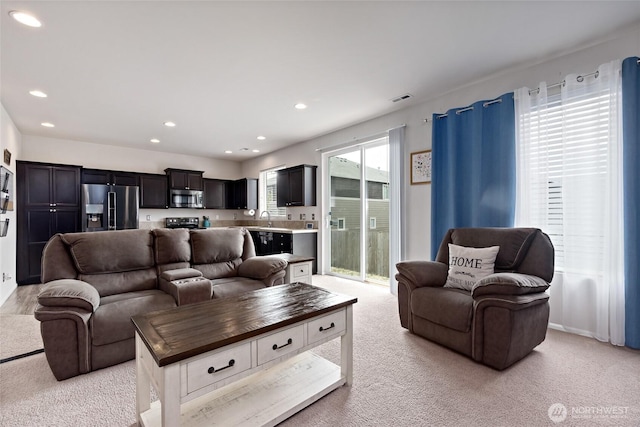 living area with light carpet, recessed lighting, and visible vents