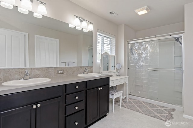 bathroom with a sink, a shower stall, double vanity, and visible vents