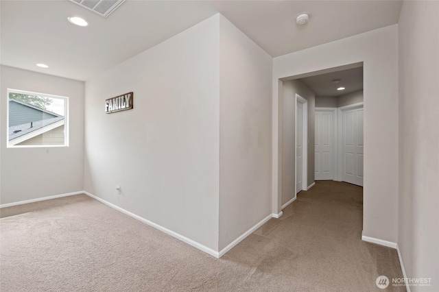 hall featuring visible vents, recessed lighting, baseboards, and light colored carpet