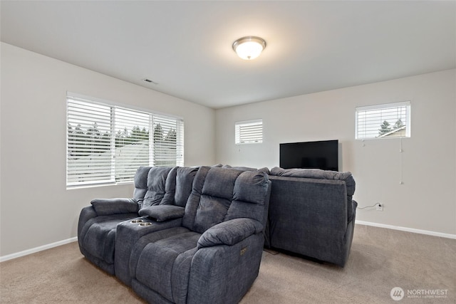 living area featuring baseboards, carpet, and a wealth of natural light