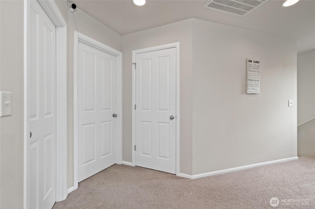 hallway with visible vents, recessed lighting, carpet, and baseboards