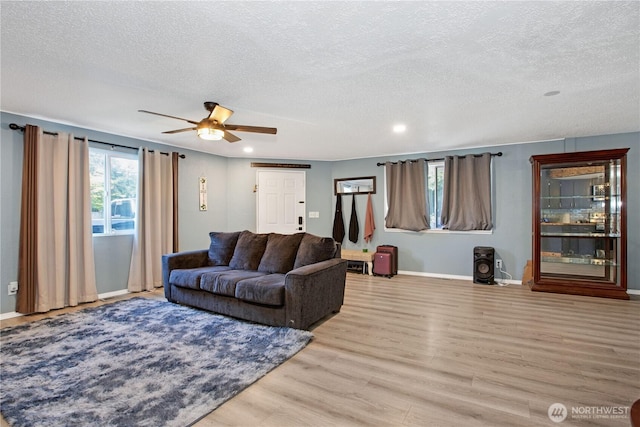 living area with recessed lighting, a textured ceiling, ceiling fan, and wood finished floors