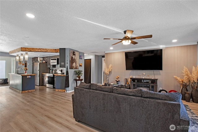 living room featuring recessed lighting, a textured ceiling, ceiling fan, and wood finished floors