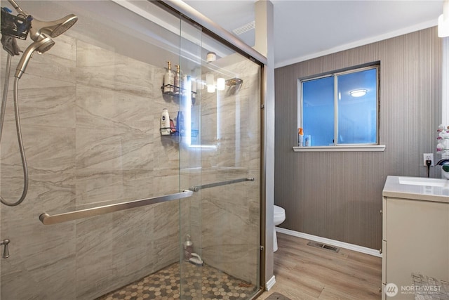 full bathroom featuring vanity, toilet, wood finished floors, visible vents, and a stall shower
