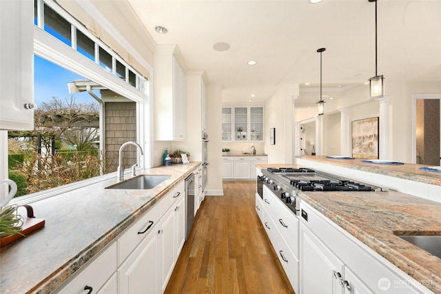 9676 Evergreen Dr, Bellevue, WA 98004 - kitchen featuring a sink, appliances with stainless steel finishes, wood finished floors, white cabinets, and hanging light fixtures