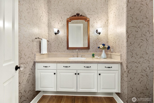 9676 Evergreen Dr, Bellevue, WA 98004 - bathroom featuring wood finished floors, vanity, wallpapered walls, and baseboards