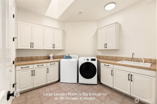 9676 Evergreen Dr, Bellevue, WA 98004 - washroom with separate washer and dryer, cabinet space, a skylight, and light tile patterned floors