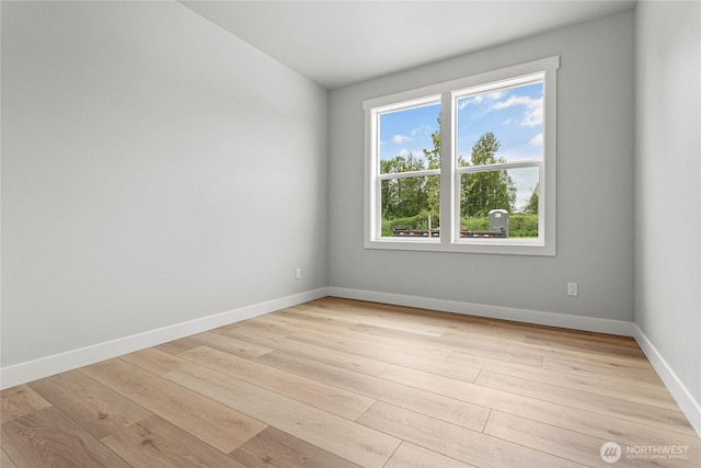 unfurnished room with light wood-type flooring and baseboards