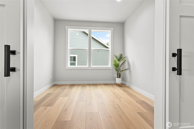 spare room featuring light wood-style floors and baseboards