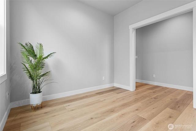 empty room with light wood-type flooring and baseboards