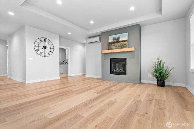unfurnished living room with a tray ceiling, recessed lighting, and a wall mounted air conditioner