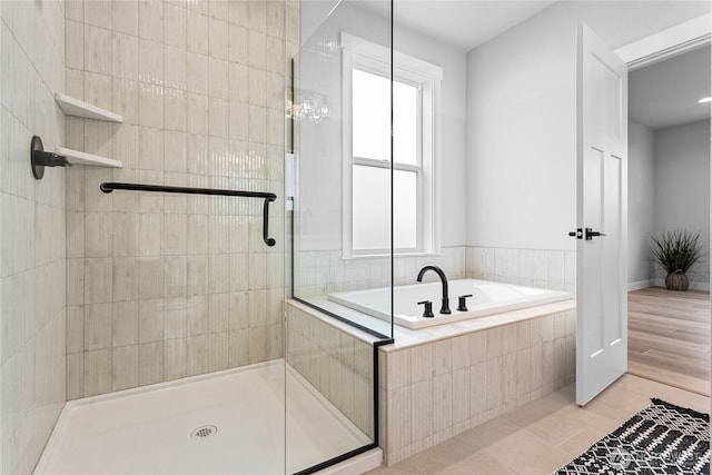 bathroom featuring tile patterned floors, a shower stall, and a bath
