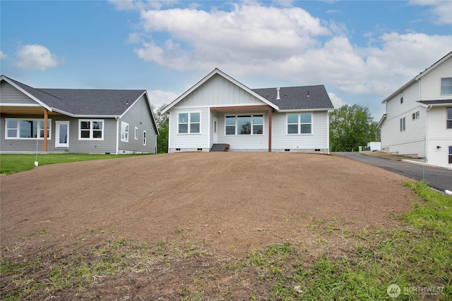 rear view of property featuring dirt driveway, board and batten siding, and crawl space