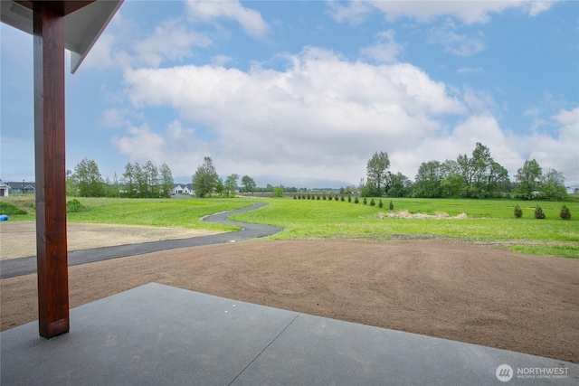 exterior space featuring a patio, a yard, and a rural view