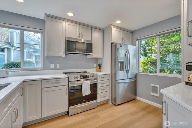 kitchen featuring light countertops, stainless steel appliances, recessed lighting, and light wood-type flooring
