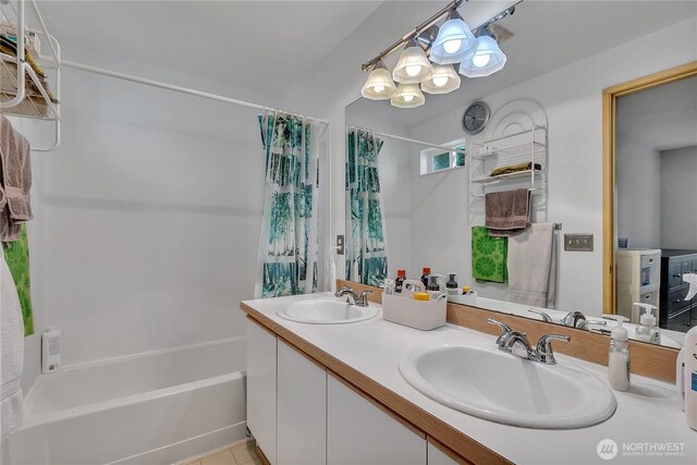bathroom featuring double vanity, a sink, and shower / tub combo