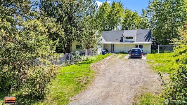 view of front of home featuring dirt driveway and fence