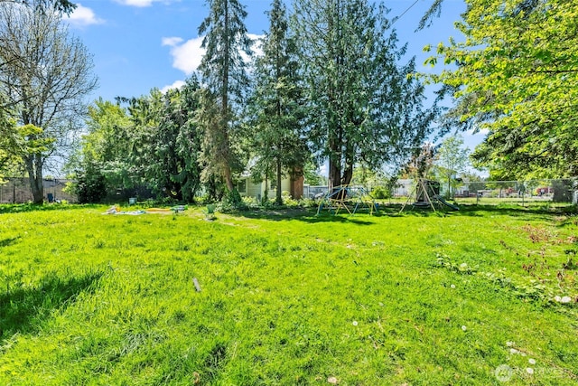 view of yard featuring fence and a playground