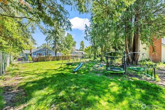 view of yard with a playground and a trampoline