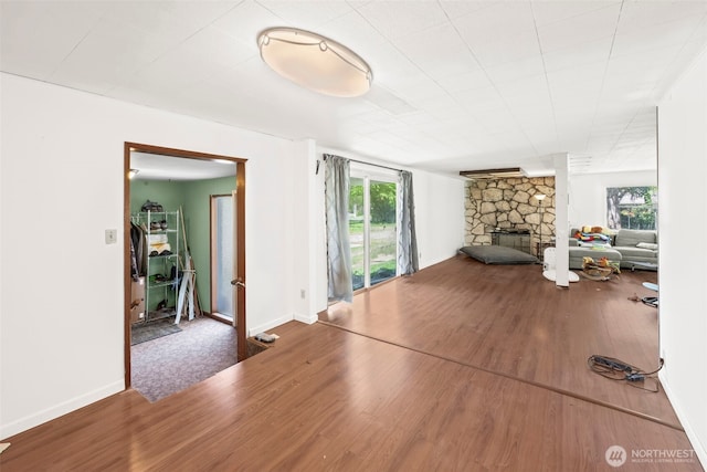 unfurnished living room with a fireplace, wood finished floors, and baseboards