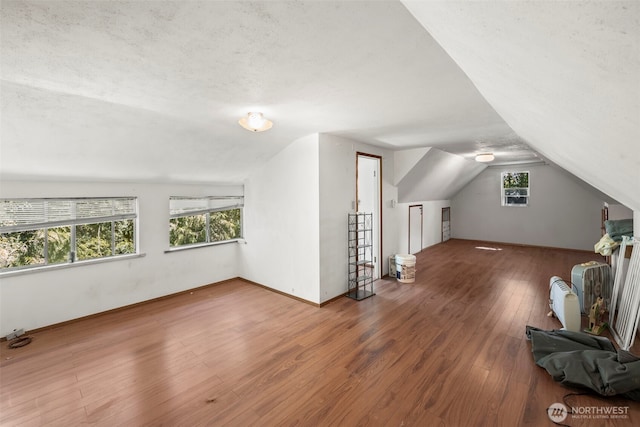 bonus room featuring wood finished floors, lofted ceiling, and baseboards
