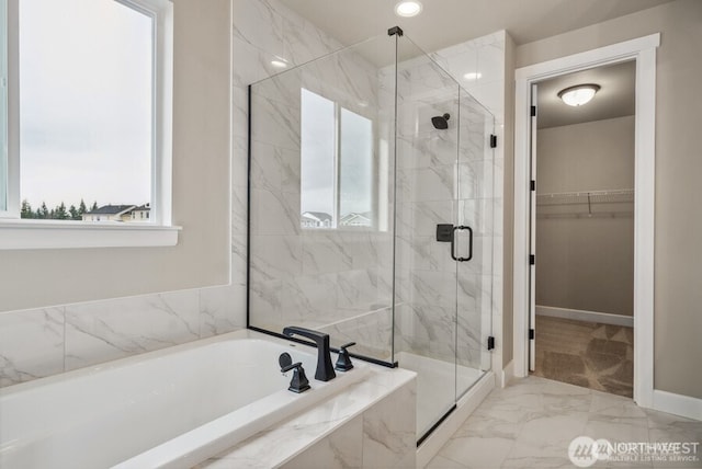 bathroom featuring a marble finish shower, a healthy amount of sunlight, and a spacious closet