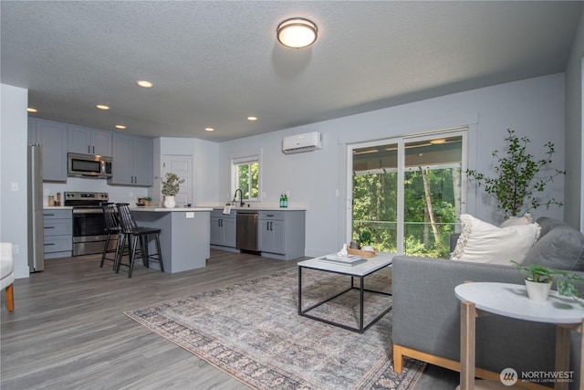 206 Oak St, Winlock, WA 98596 - living area with light wood-type flooring, an AC wall unit, recessed lighting, and a textured ceiling