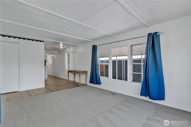 unfurnished room with carpet flooring and wood finished floors