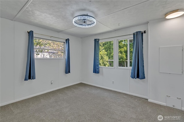 unfurnished room with baseboards, plenty of natural light, and carpet