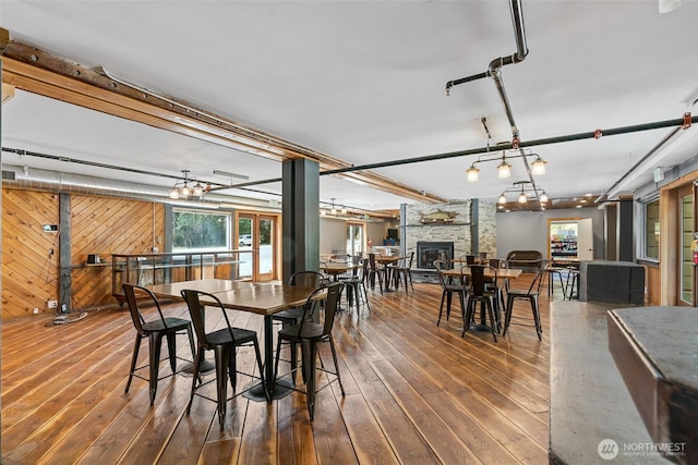 27510 Hwy 97, Cle Elum, WA 98922 - dining space featuring a stone fireplace, wood walls, and hardwood / wood-style floors