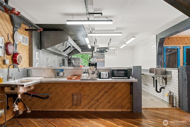 27510 Hwy 97, Cle Elum, WA 98922 - kitchen featuring wood-type flooring, a sink, a toaster, stainless steel microwave, and wooden walls