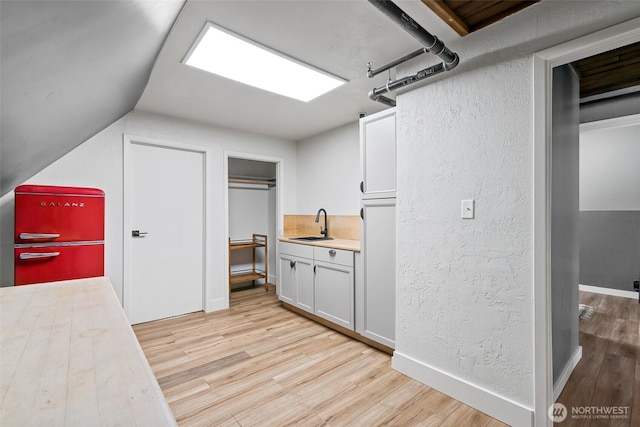 27510 Hwy 97, Cle Elum, WA 98922 - interior space featuring a sink, a textured wall, baseboards, and light wood-style floors