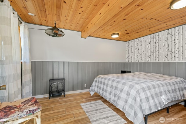 27510 Hwy 97, Cle Elum, WA 98922 - bedroom with wooden ceiling, a wood stove, a wainscoted wall, and wood finished floors