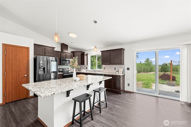 kitchen with dark brown cabinets, appliances with stainless steel finishes, dark wood-type flooring, backsplash, and vaulted ceiling