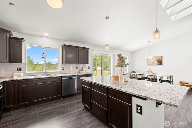 kitchen with decorative backsplash, a kitchen island, dark wood-style floors, a sink, and dishwasher