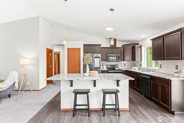 kitchen featuring dark brown cabinetry, a center island, tasteful backsplash, vaulted ceiling, and stainless steel appliances