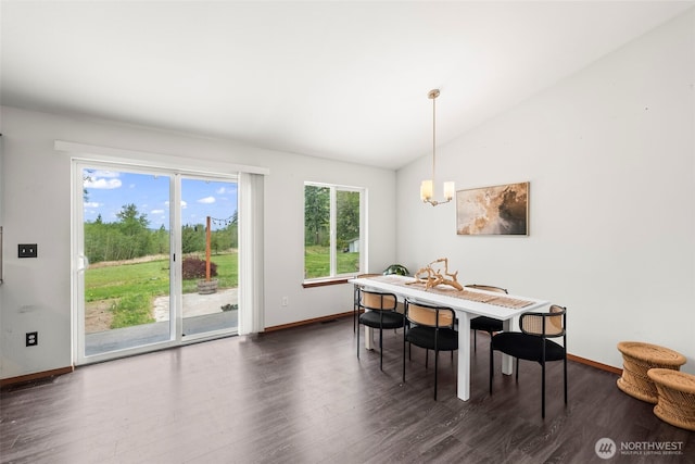 dining space featuring baseboards, lofted ceiling, dark wood-style flooring, and a notable chandelier