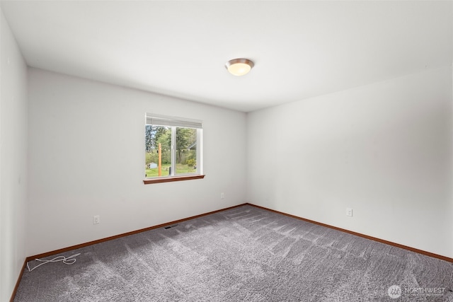 spare room featuring carpet floors, baseboards, and visible vents