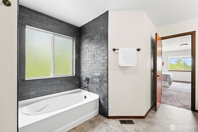 full bath with a bathing tub, baseboards, ensuite bath, and visible vents