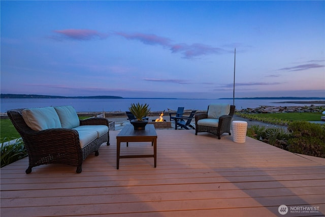 deck featuring a water view and an outdoor living space with a fire pit