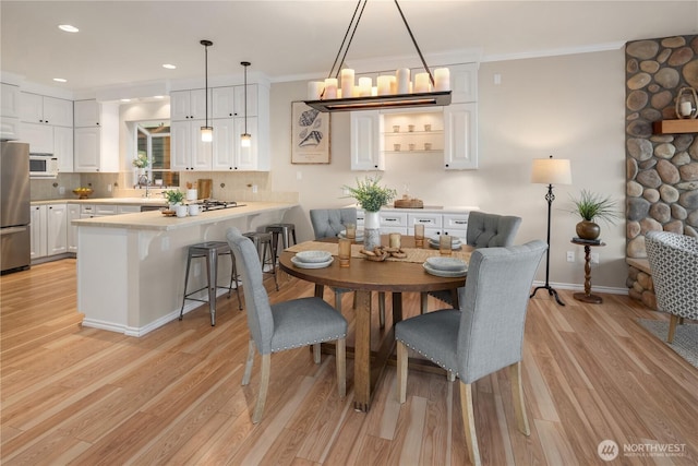 dining room with recessed lighting, an inviting chandelier, ornamental molding, and light wood-type flooring