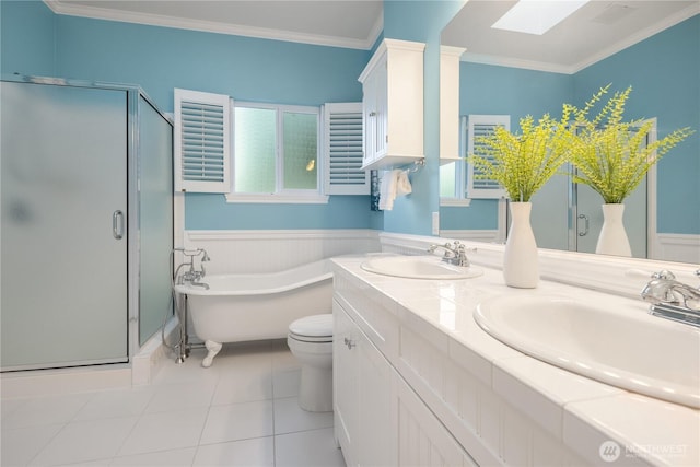 full bath featuring crown molding, a soaking tub, a skylight, and a sink