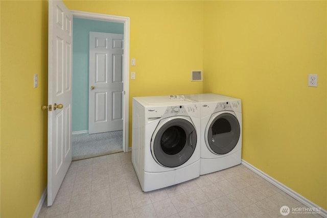 washroom featuring laundry area, washer and clothes dryer, baseboards, and light tile patterned floors