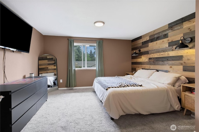 carpeted bedroom featuring baseboards and wood walls