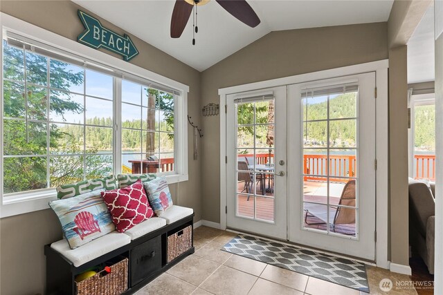 doorway with lofted ceiling, light tile patterned flooring, baseboards, french doors, and a ceiling fan