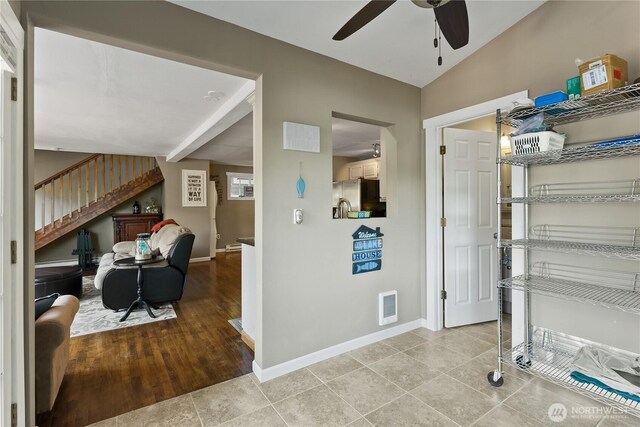 interior space with a ceiling fan, baseboards, light tile patterned floors, and stairway