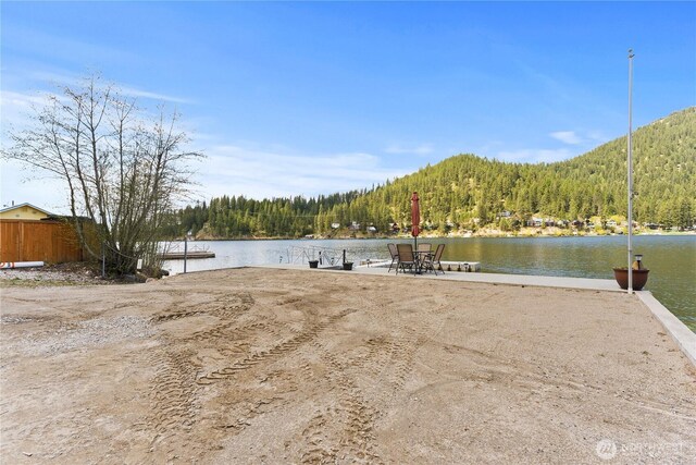 dock area with a water view and a forest view