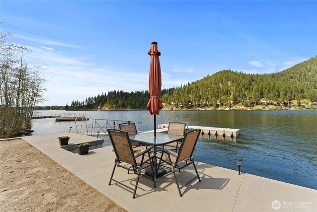 dock area with a water view and a wooded view