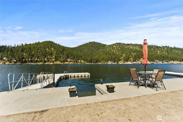dock area featuring a water and mountain view and a wooded view